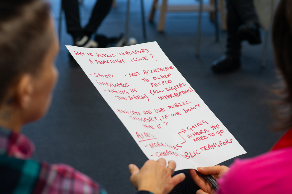 workshop image with sheet of paper listing why public transport is a feminist issue