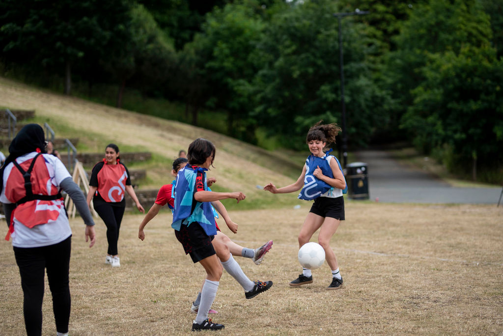 three teams play co-operative football in colourful geometric strips